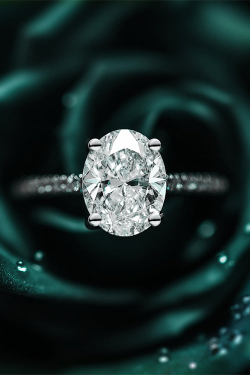 Oval diamond solitaire engagement ring on Green floral background