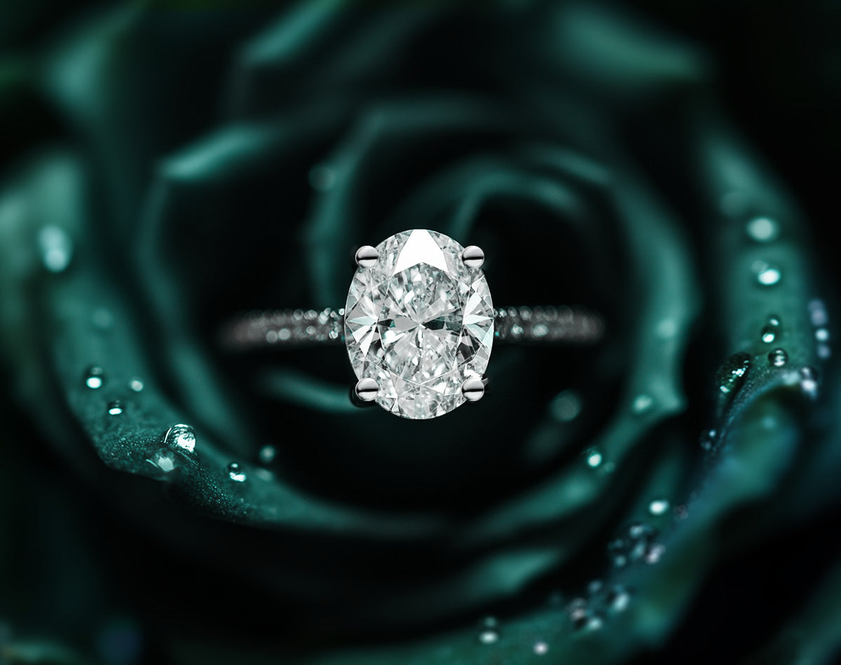 Oval diamond solitaire engagement ring on Green floral background